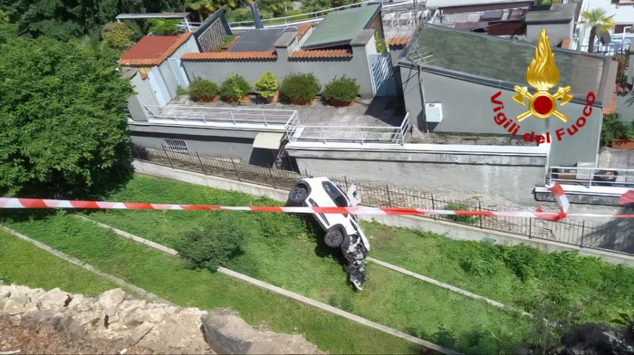 Auto sfonda muretto e precipita nel giardino di una villa